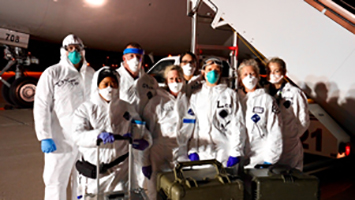A photo of jets at night and the medical personnel who were waiting on evacuees to be quarantined for 14 days to help prevent the spread of the Coronavirus (COVID-19)