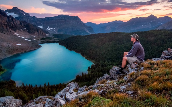 Train yourself never to put off the word or action for the expression of gratitude, image of someone at the top of a mountain overlooking a glacial lake