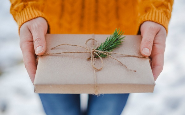 Feeling gratitude and not expressing it is like wrapping a present and not giving it, image of someone holding a wrapped present