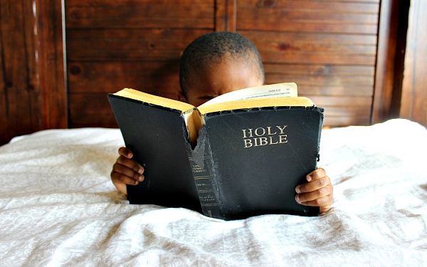 Let gratitude be your pillow upon which you kneel to say your nightly prayer, image of child reading bible