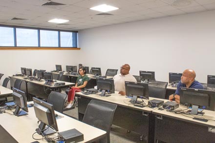 A photo showing three students sitting in a classroom at Saint Leo University's MacDill Education Center