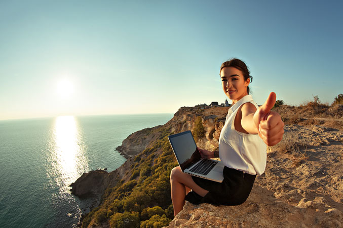 earn an online business degree, image of young woman sitting at a computer