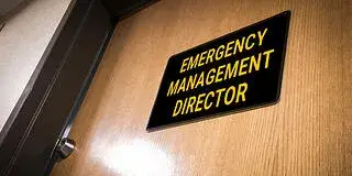 A photo showing a sign that says 'Emergency Management Director,' an example of a critical incident management career role; Saint Leo University's graduate criminal justice degree program can help grads attain this position