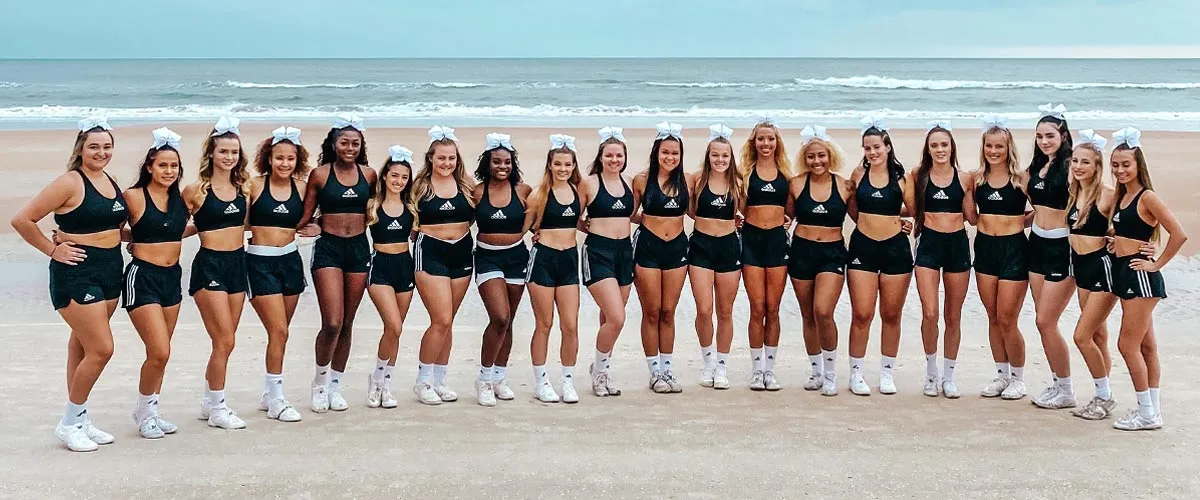 Saint Leo University cheerleading team posing on the beach