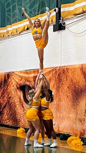 Saint Leo University cheerleading tower courtside at home basketball game