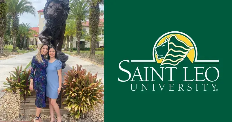 A photo of Isa Riano, a rising junior at Saint Leo University, standing with her mom at University Campus in front of the lion statue; both are dressed nicely wearing dark-colored dresses