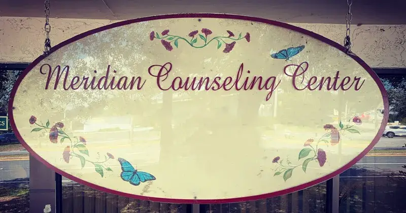 A photo showing the logo for Meridian Counseling Center, the private counseling practice operated by Saint Leo University Master of Social Work degree program alumna Emily Gilbert, with a cityscape of buildings in the background