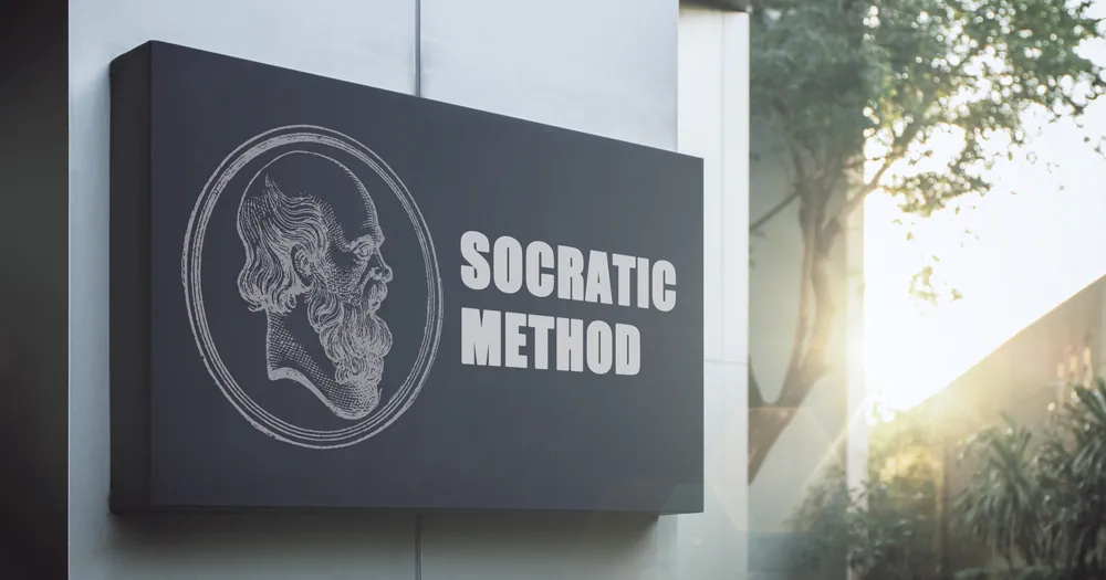 A photo showing an outdoor sign that says 'Socratic method' with the sky and a tree visible in the background; this is for the blog article on the Socratic method of teaching and examples of the Socratic method of teaching