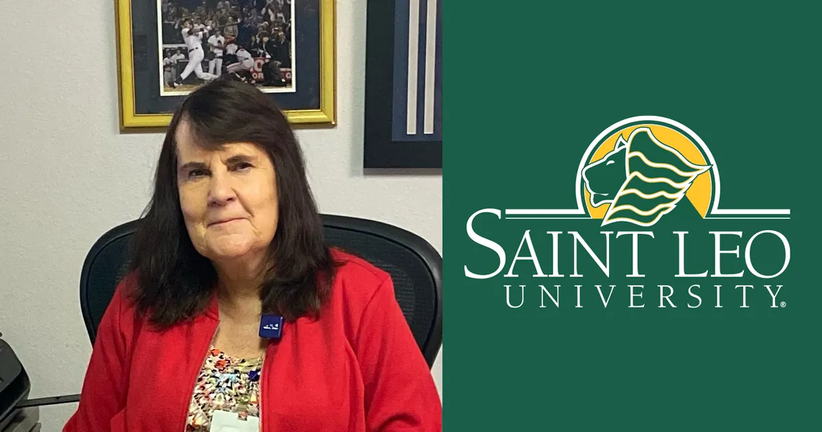 A photo of Kathleen Clark, a 1987 undergraduate Saint Leo psychology degree alumna, sitting in her office and smiling
