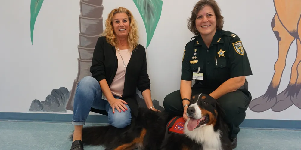 A photo of Julie Sanderson (left), a Saint Leo MSW alumna, with Patriot Service Dogs graduate, Tank (a Bernese Mountain Dog), and Capt. Renee Graham of the Nassau County, FL Sheriff's Office