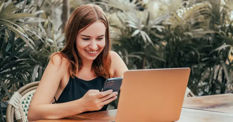 A photo of a female college student using her smartphone for the blog article on the best apps for social work majors