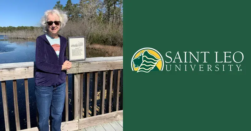 A photo of Deb Adams, a 1996 alumna of the Saint Leo business administration degree program, wearing sunglasses standing on a bridge on a sunny day