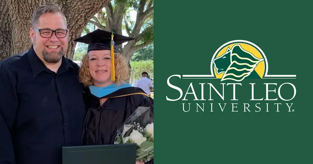 A photo of Angela and Tim Falleur who are both Saint Leo alumni; this photo was taken outside after Angela’s commencement ceremony for her master’s degree in exceptional student education; Angela is wearing her cap and gown and holding a bouquet of flowers, while Tim is dressed nicely.