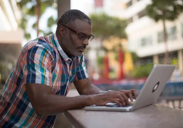 male adult student using laptop