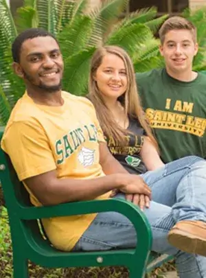 students, wearing Saint Leo University shirts, sitting on bench together