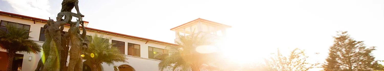 image of statue with clocktower and morning sun shining through