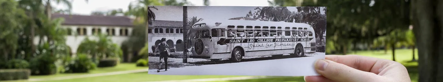 image of old photo of bus on campus being held in same spot it was originally taken