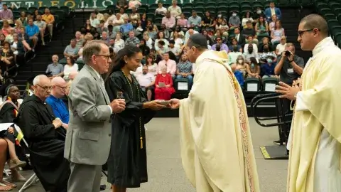 Graduate Kennedy Messina and Trustee Chair John View present the gifts to Abbot Camacho and Father Amarillas