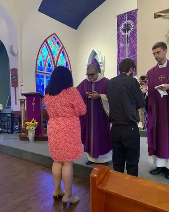 Veronica Vasquez and Jason Kaczynski receive Communion from Father Lucius and Father Randall