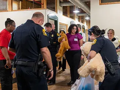 Tampa Police Department officers gather teddy bears.