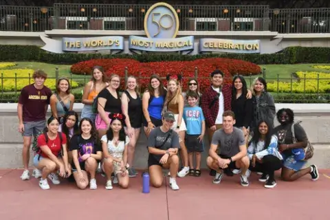 A few Saint Leo University students from the class on Disney psychology posing in front of the Disney entrance when the class visited the Magic Kingdom in October of 2022