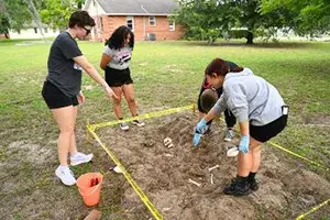 Instructor Cassie Heister shows student how to examine bones